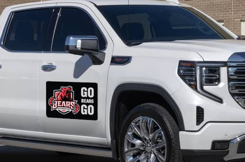 White truck with a Truck magnet on the side door.