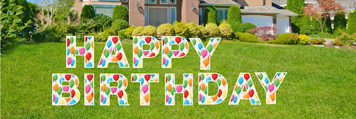 "Happy Birthday" yard letter signs displayed in the front yard of a home.